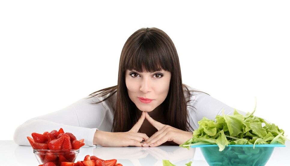 femme à la table avec des herbes et des fraises